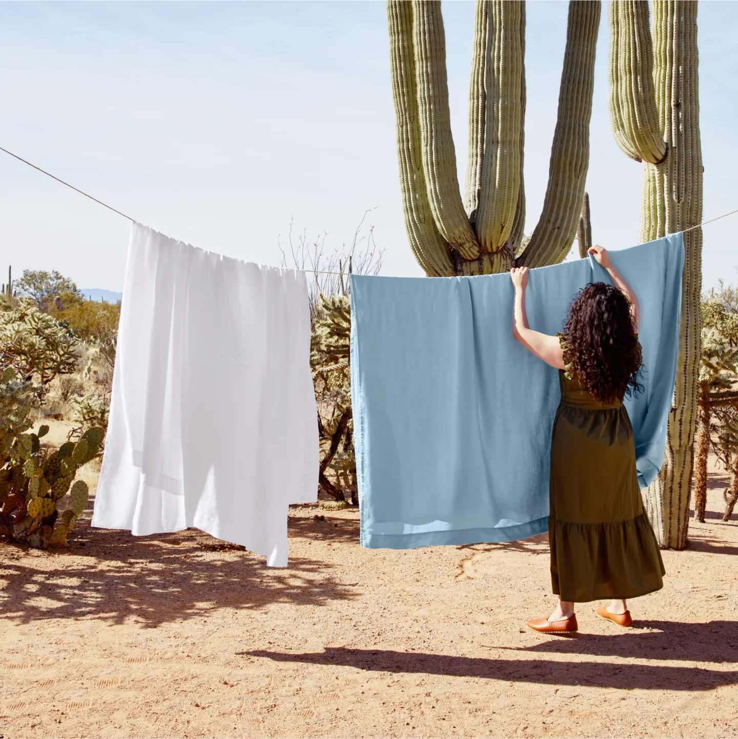 woman hanging laundry in desert setting