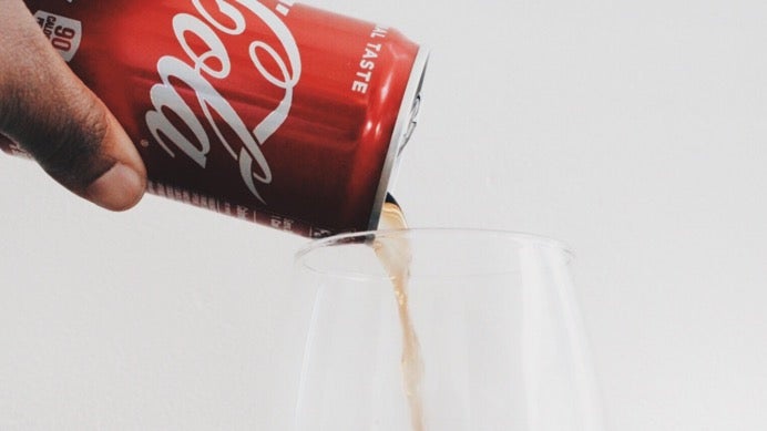 Red soda can pouring into glass