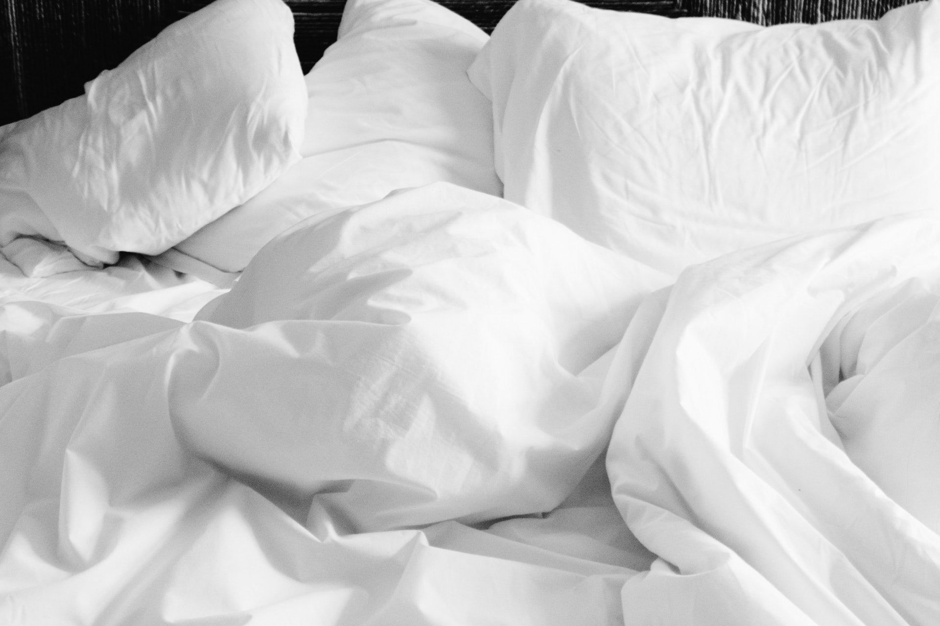 Crumpled white bedding in soft light