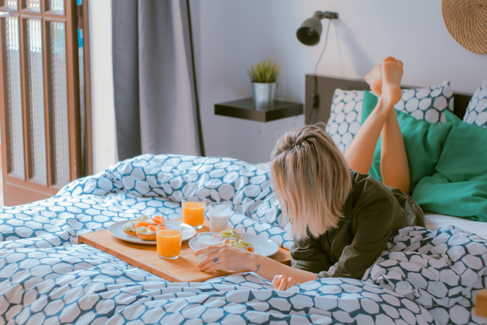 Woman relaxing with breakfast in bed