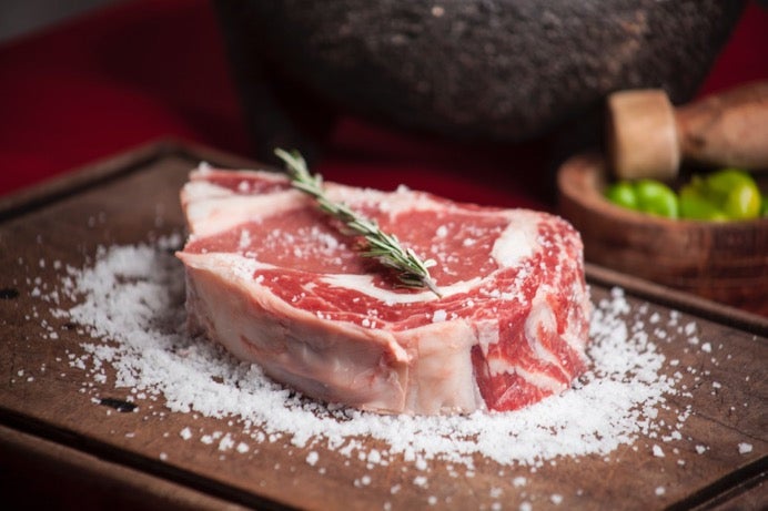 Raw steak with rosemary and coarse salt