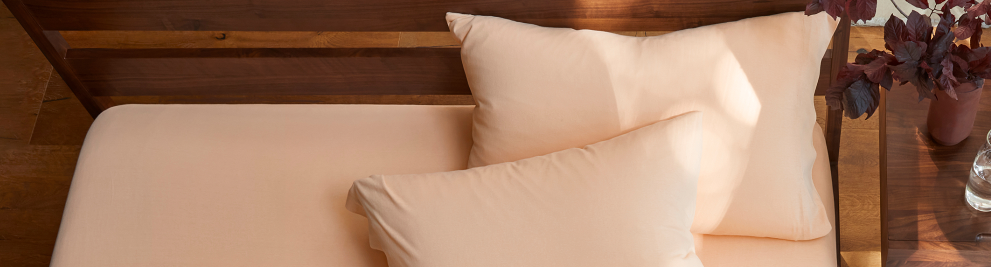 cozy bed with melon colored pillowcases