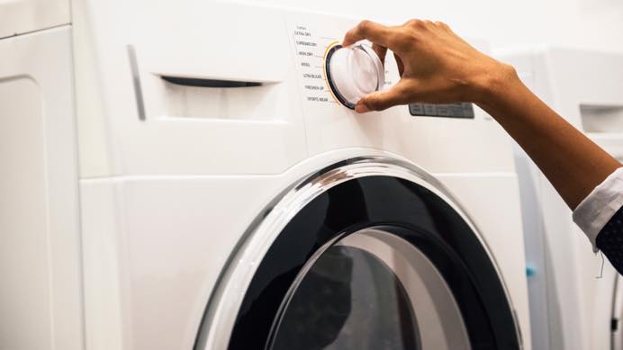 Hand adjusting washing machine settings