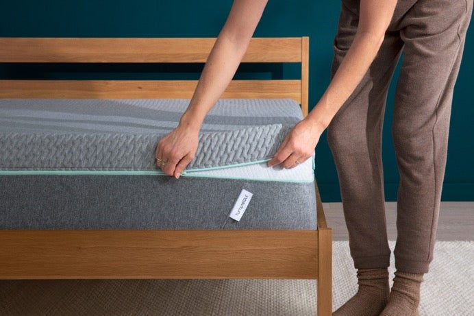Person adjusting foam mattress topper