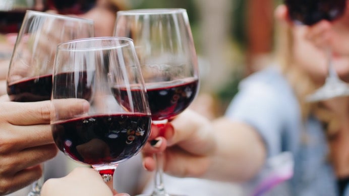 Group toasting with red wine glasses