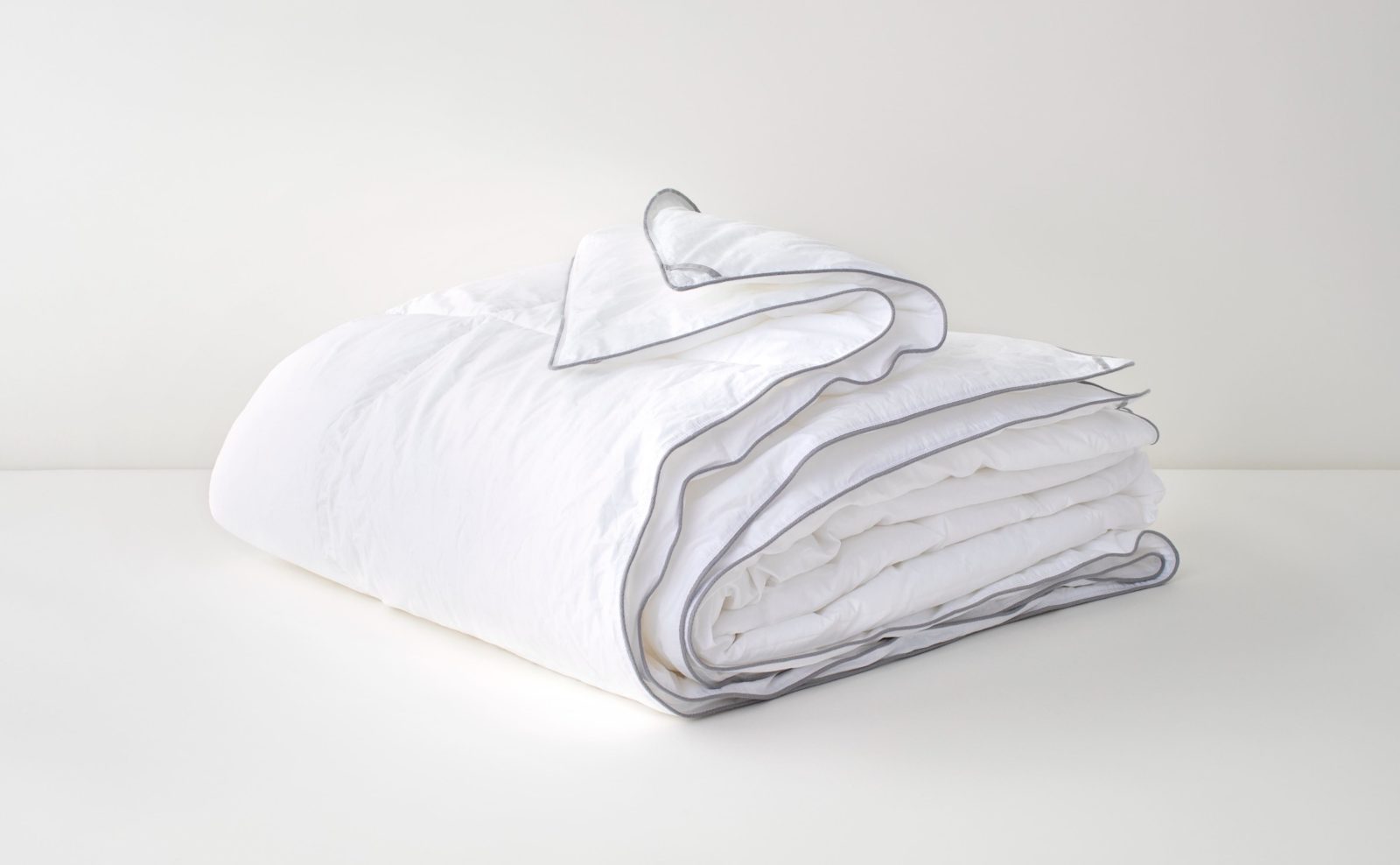 Folded white comforter with gray trim