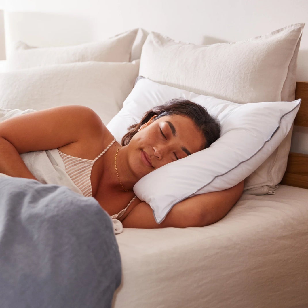 Woman resting on white bedding