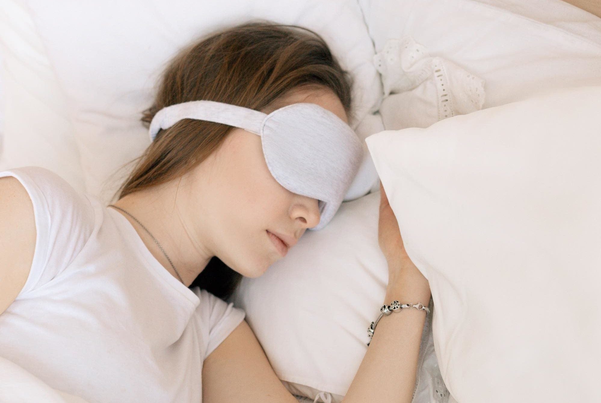 Woman sleeping with eye mask in bed