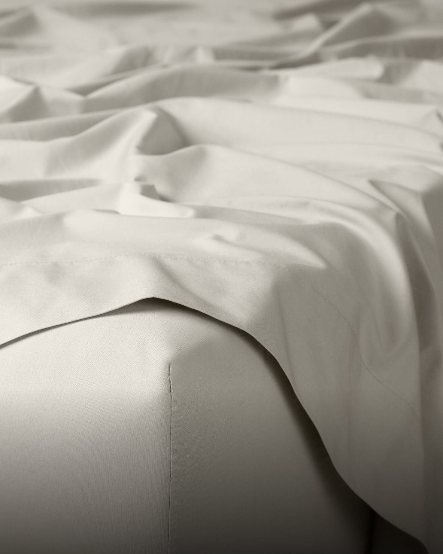 White sheets draping off a bed
