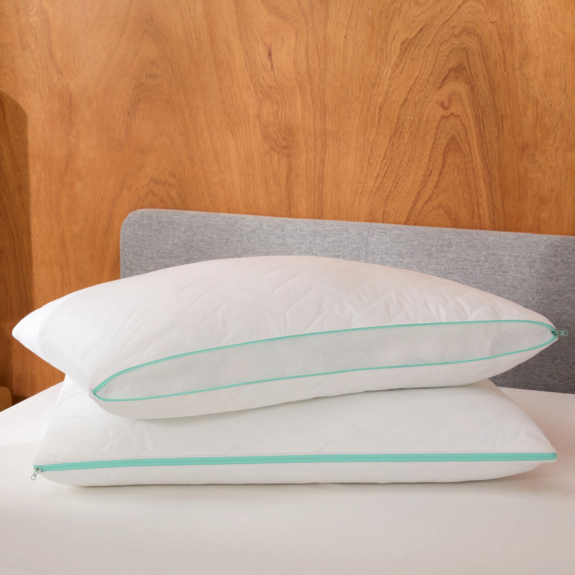 White pillows with teal accents on bed