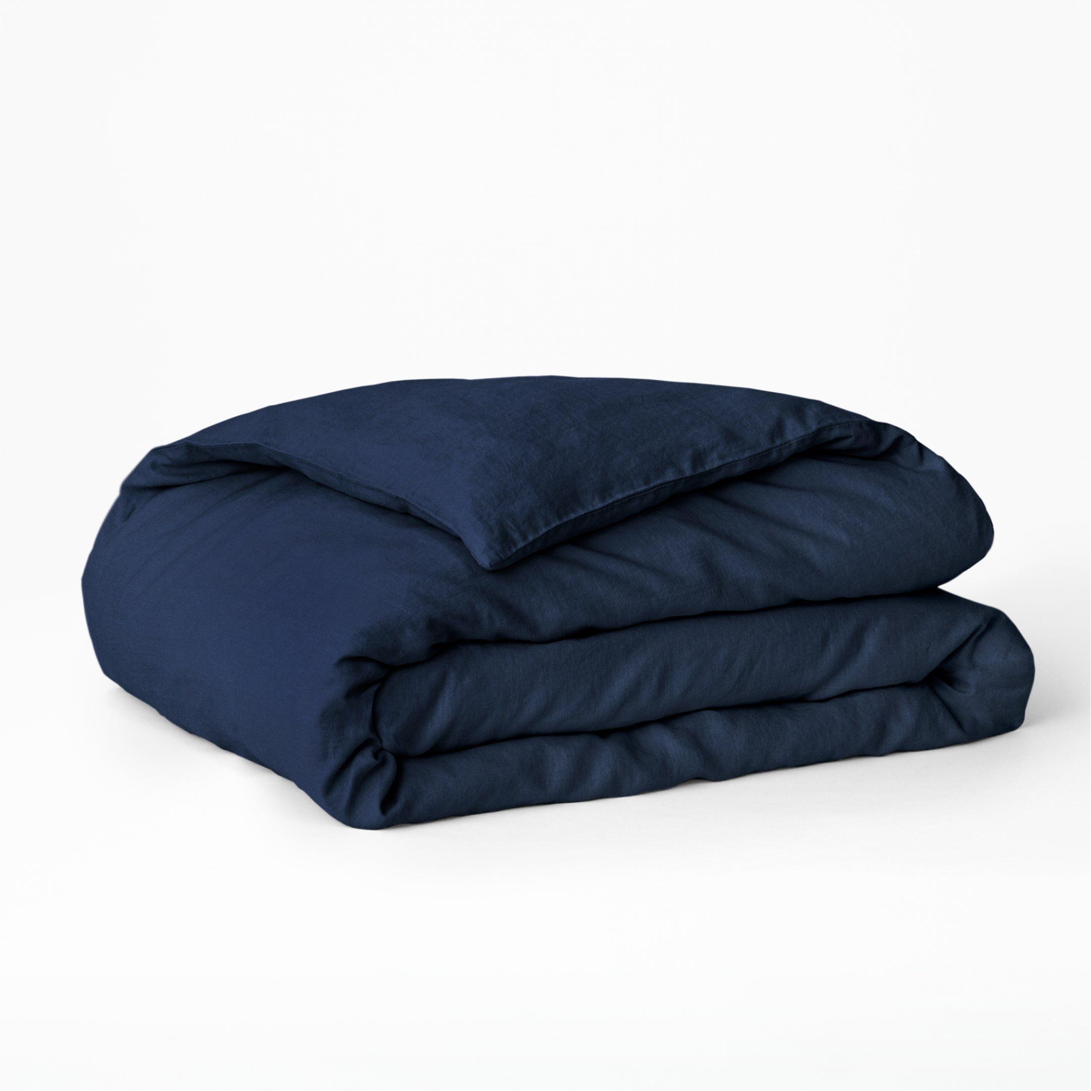 Folded navy blue comforter on a white background